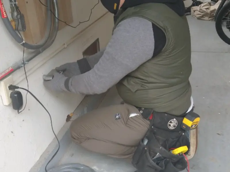 Electrician performing outlet wiring in a Andalusia garage